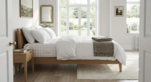 A spacious king-size luxury pocket spring mattress dressed in crisp white linen on a modern wooden bed frame in a bright British master bedroom.